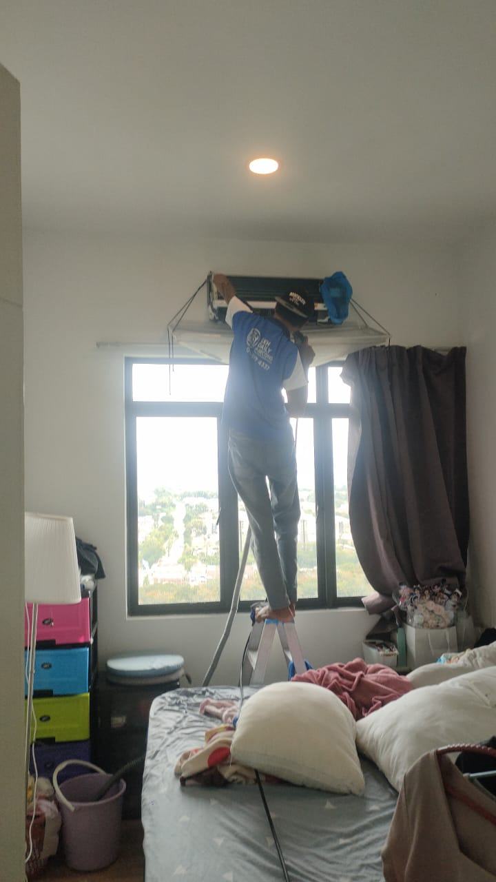Aircond cleaning in a bedroom with cover sheet